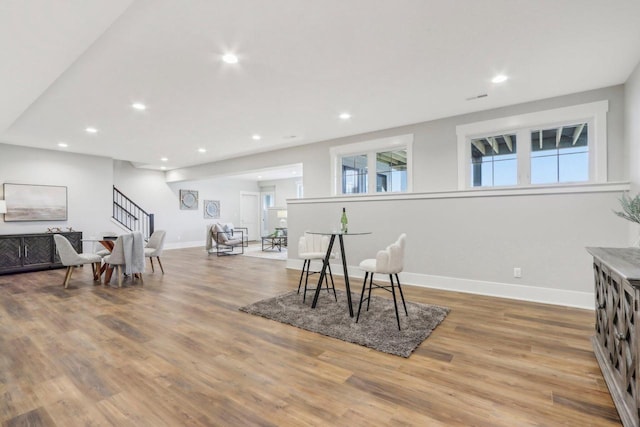 interior space featuring visible vents, baseboards, stairs, recessed lighting, and wood finished floors