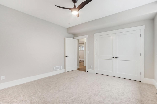 unfurnished bedroom featuring visible vents, baseboards, carpet, a closet, and a ceiling fan