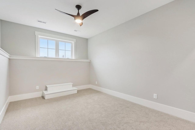 carpeted empty room featuring visible vents, baseboards, and a ceiling fan