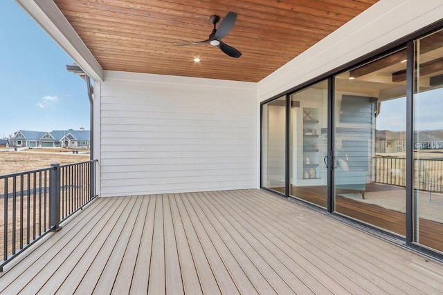 wooden deck with a residential view and a ceiling fan