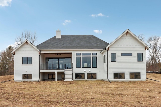 back of property featuring a chimney and roof with shingles