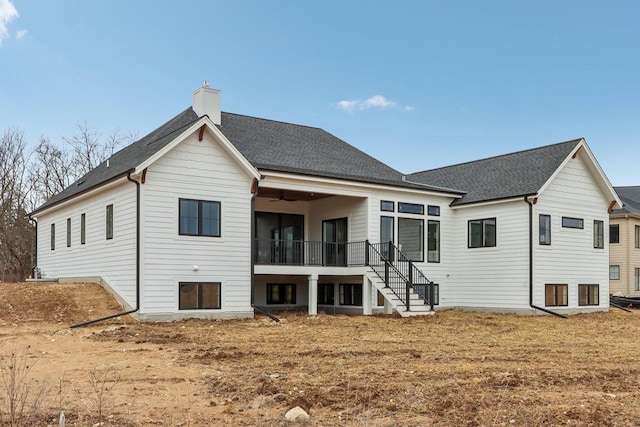 back of property with a chimney, stairs, and roof with shingles