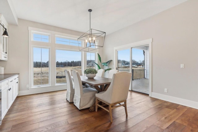 dining room featuring baseboards, a notable chandelier, and hardwood / wood-style floors