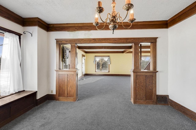 unfurnished room with a notable chandelier, carpet floors, a textured ceiling, and baseboards