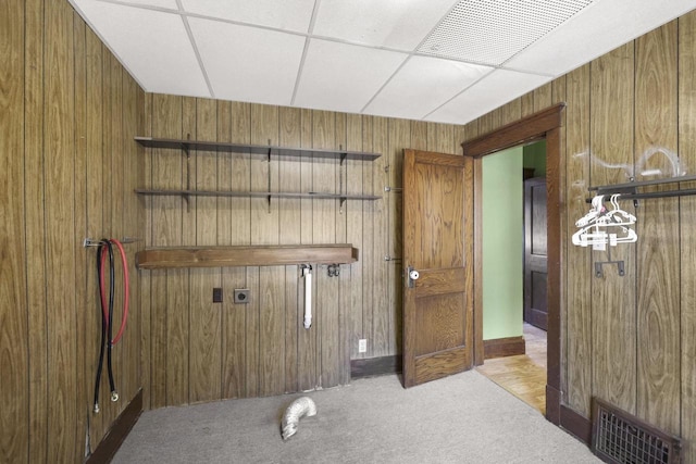 washroom featuring visible vents, carpet, and wooden walls