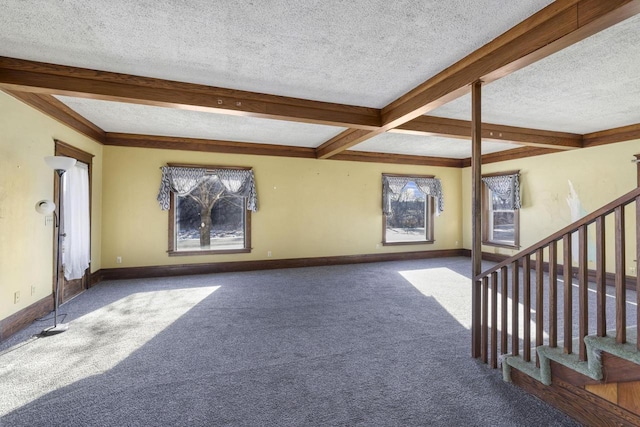 unfurnished living room featuring beamed ceiling, carpet flooring, baseboards, and a textured ceiling