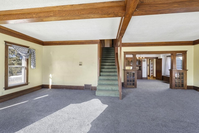 unfurnished living room featuring baseboards, stairway, ornamental molding, carpet flooring, and an inviting chandelier