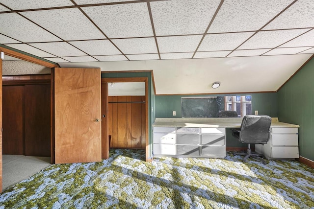 home office with a drop ceiling, carpet, and wooden walls