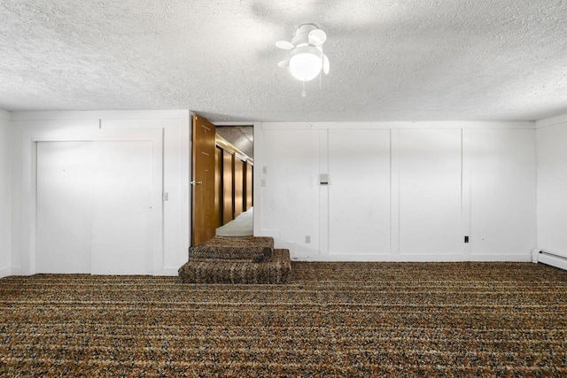 spare room featuring a decorative wall, a textured ceiling, stairs, and carpet