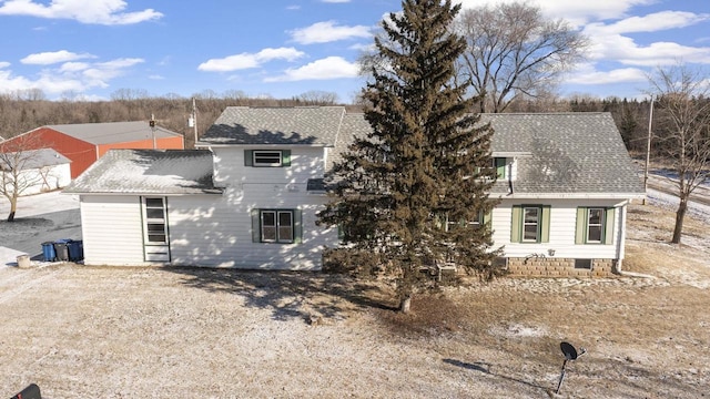 exterior space with driveway and roof with shingles