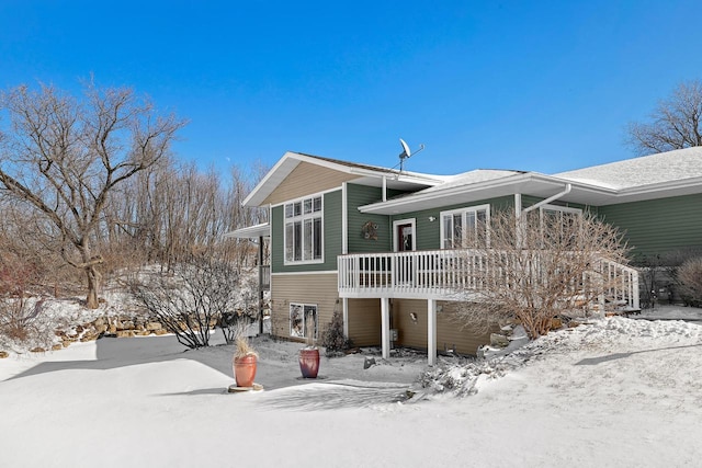 snow covered house with a wooden deck