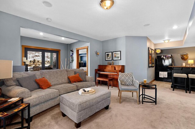 living area with a dry bar, light colored carpet, french doors, and baseboards