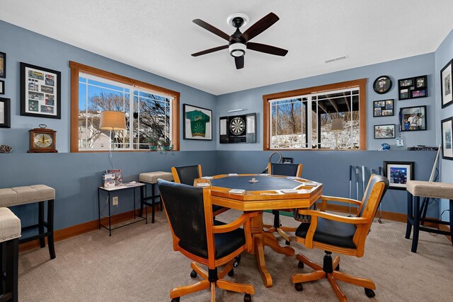 carpeted office space featuring visible vents, a textured ceiling, a ceiling fan, and baseboards