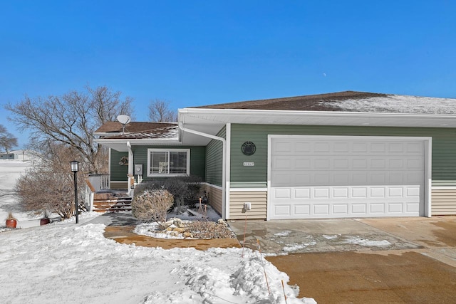 view of front facade featuring an attached garage, driveway, and roof with shingles