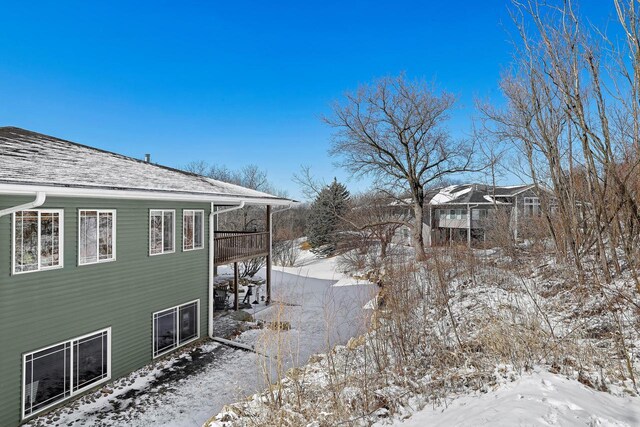 view of snow covered exterior featuring a shingled roof