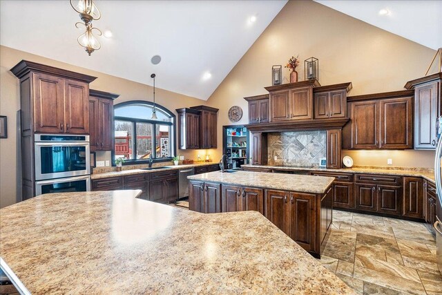 9073 Richfield Dr, Marshfield, WI 54449 - kitchen featuring stainless steel double oven, dark brown cabinets, a kitchen island, and a sink
