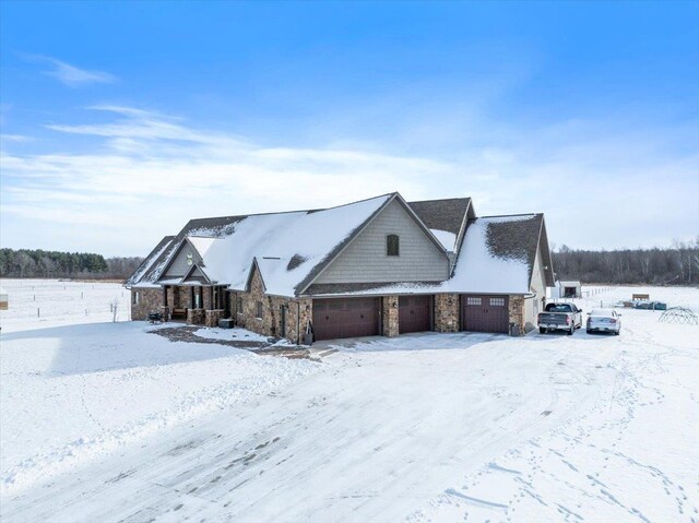 9073 Richfield Dr, Marshfield, WI 54449 - view of snow covered exterior with a garage and stone siding