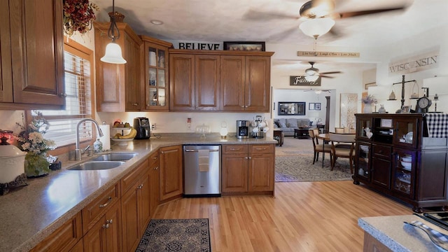 kitchen with stainless steel dishwasher, light wood-style flooring, brown cabinets, and a sink