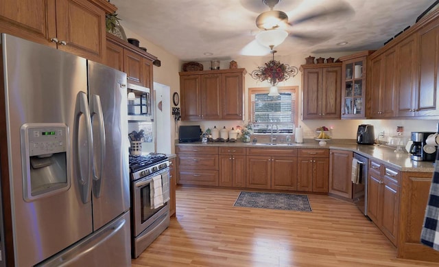 kitchen with brown cabinets, appliances with stainless steel finishes, and a sink