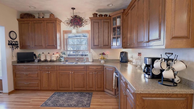 kitchen with a sink, brown cabinetry, and light wood finished floors