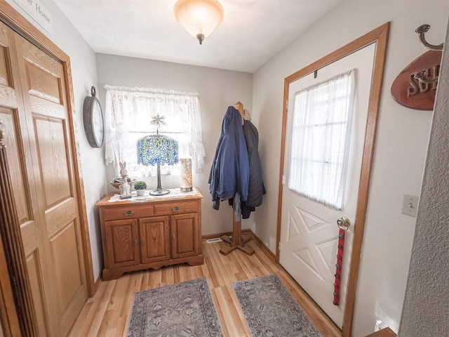 doorway to outside featuring light wood-type flooring and baseboards