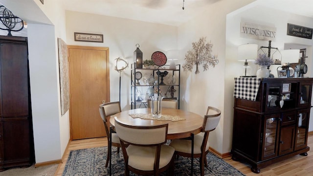 dining space featuring light wood-style floors and baseboards