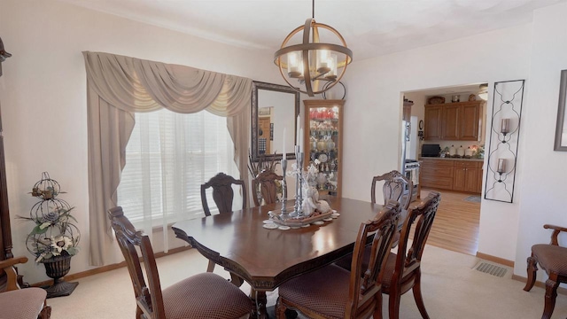 dining space featuring visible vents, baseboards, and an inviting chandelier