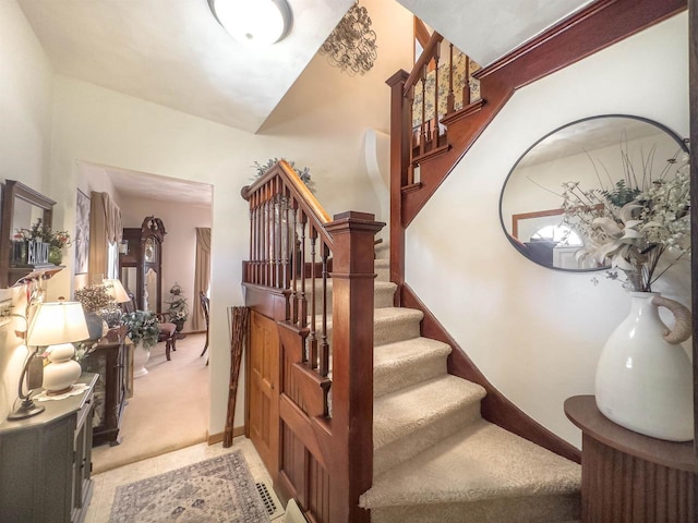 stairway featuring baseboards and carpet