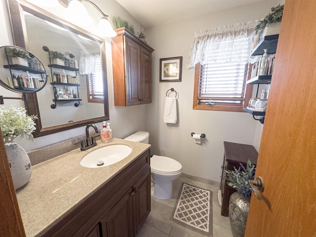 bathroom featuring tile patterned floors, baseboards, toilet, and vanity