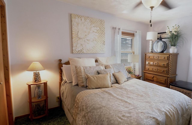 bedroom with dark carpet and a ceiling fan