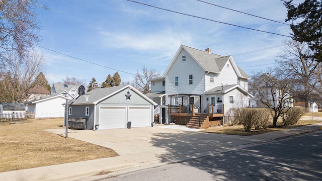 view of front of house featuring a front yard, fence, a wooden deck, an outdoor structure, and concrete driveway