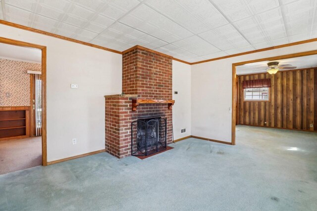 unfurnished living room with ornamental molding, a brick fireplace, baseboards, and carpet floors