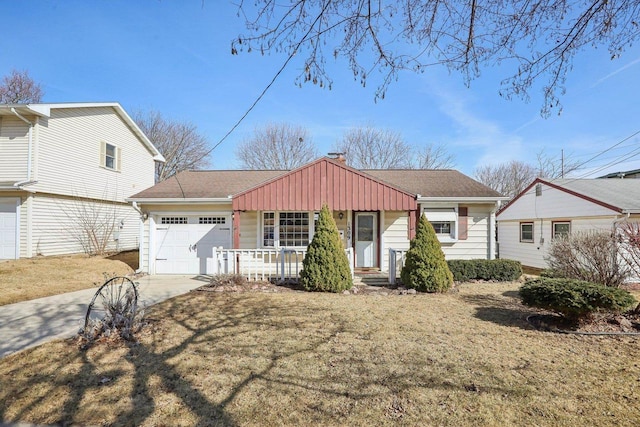 view of front facade featuring driveway, a porch, an attached garage, a shingled roof, and a chimney