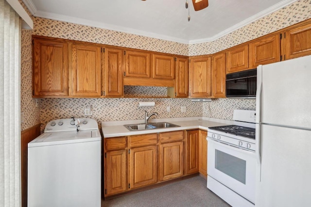 kitchen with white appliances, washer / clothes dryer, a sink, light countertops, and brown cabinets