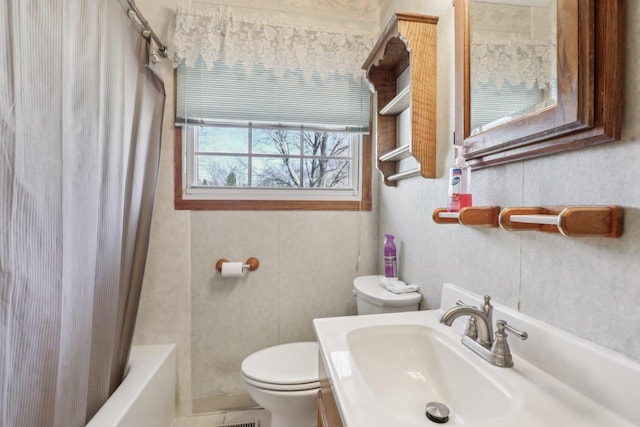 bathroom with vanity, shower / tub combo, and toilet