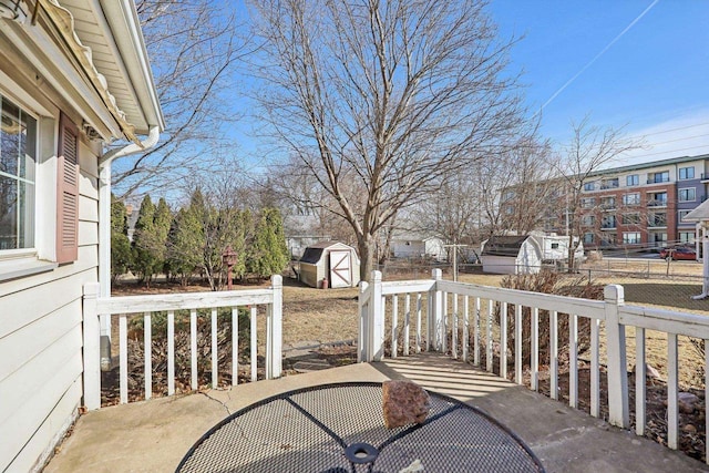 view of patio featuring a storage shed, an outdoor structure, and fence