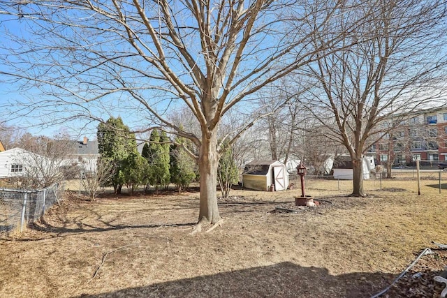 view of yard with an outbuilding, a shed, and fence