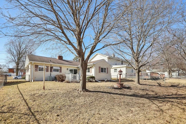 back of property featuring a chimney and fence