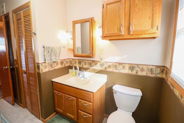 bathroom with vanity, toilet, and a closet