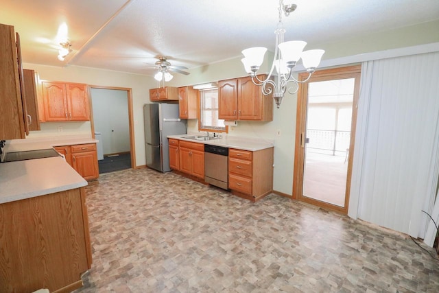 kitchen with pendant lighting, light countertops, ceiling fan with notable chandelier, stainless steel appliances, and a sink