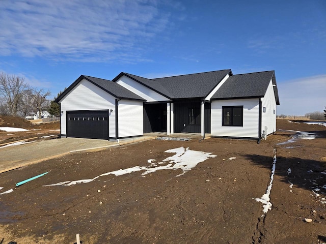 view of front of property featuring driveway, roof with shingles, and an attached garage