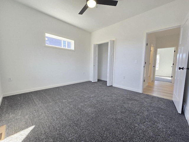 unfurnished bedroom featuring baseboards, carpet, and a ceiling fan