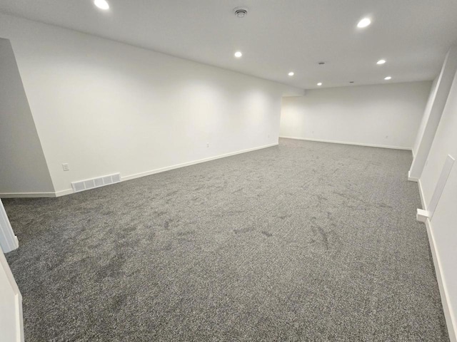 empty room with visible vents, recessed lighting, dark carpet, and baseboards