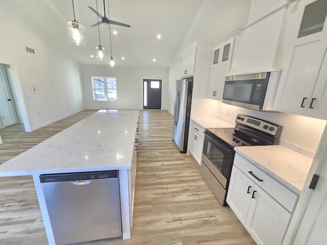 kitchen featuring visible vents, a kitchen island, open floor plan, light wood-type flooring, and appliances with stainless steel finishes