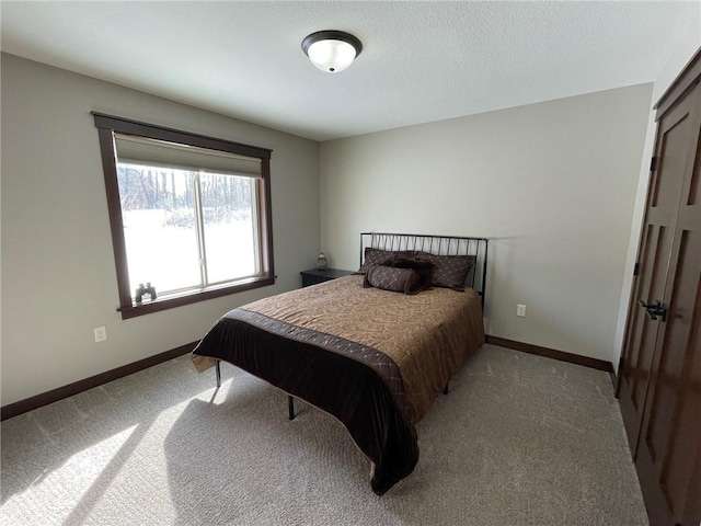 carpeted bedroom featuring baseboards and a textured ceiling