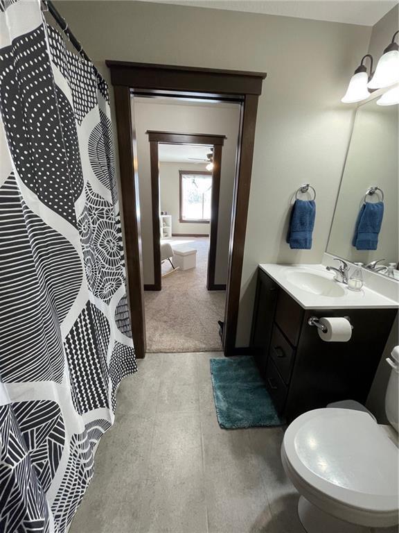 bathroom with a notable chandelier, toilet, curtained shower, and vanity