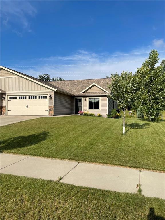 ranch-style home with a front yard, an attached garage, and driveway