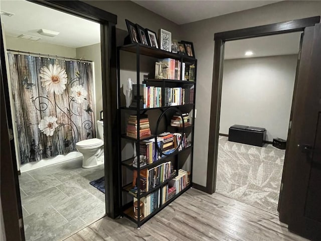 hallway featuring wood finished floors and baseboards