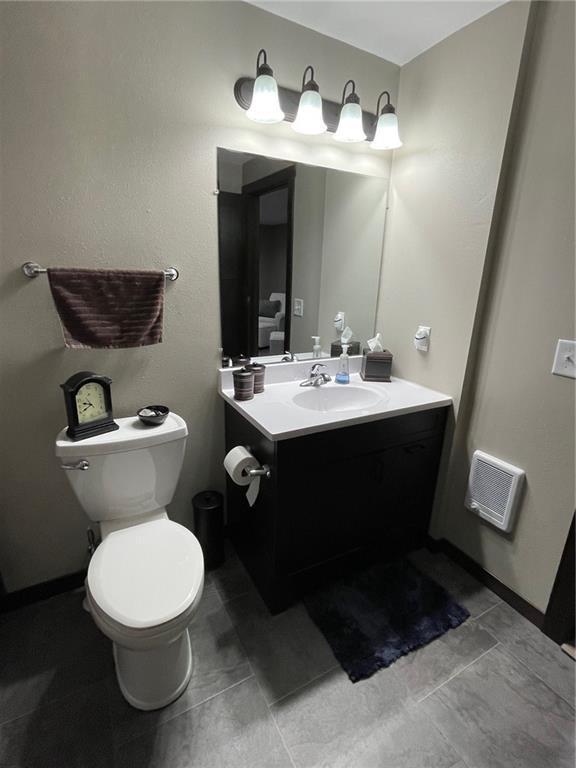 bathroom featuring visible vents, toilet, and vanity