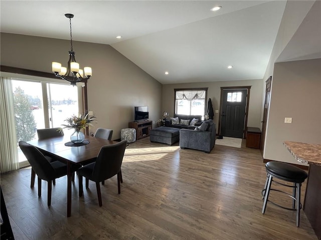 dining area featuring lofted ceiling, recessed lighting, wood finished floors, and a chandelier